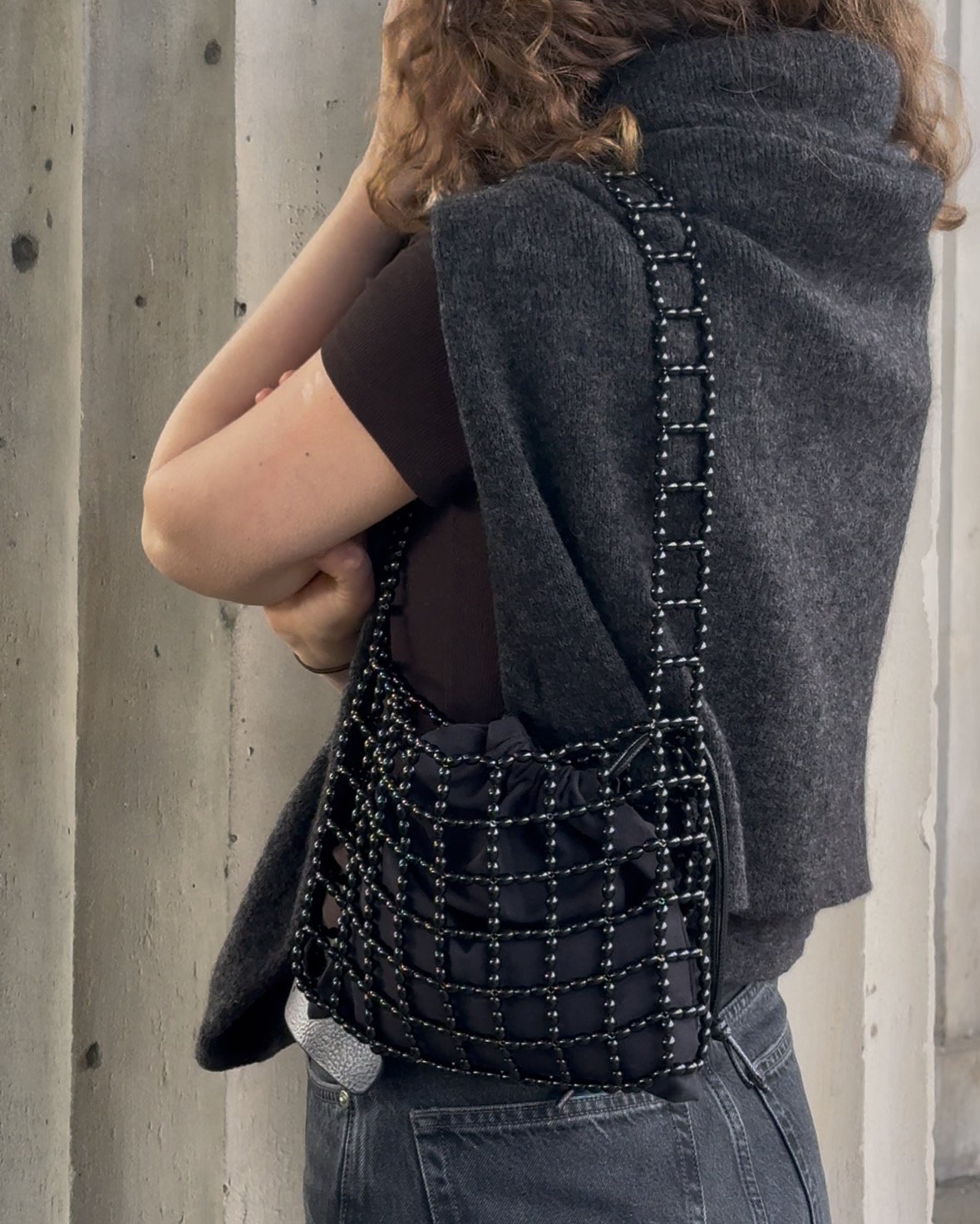 A compact shoulder bag made of interlinked black beads with a structured, grid-like design. Lightweight yet durable, it fits essentials and adds a clean, modern accent to everyday outfits.

Approx. 21 cm x 17 cm
Strap length - 28 cm

Black glass beads
Includes a removable black cotton pouch

We recommend carrying only essentials such as your phone, lipstick, wallet and sunglasses. Since we use metal thread for weaving, we advise avoiding direct contact with water.

Handcrafted in Kyiv

