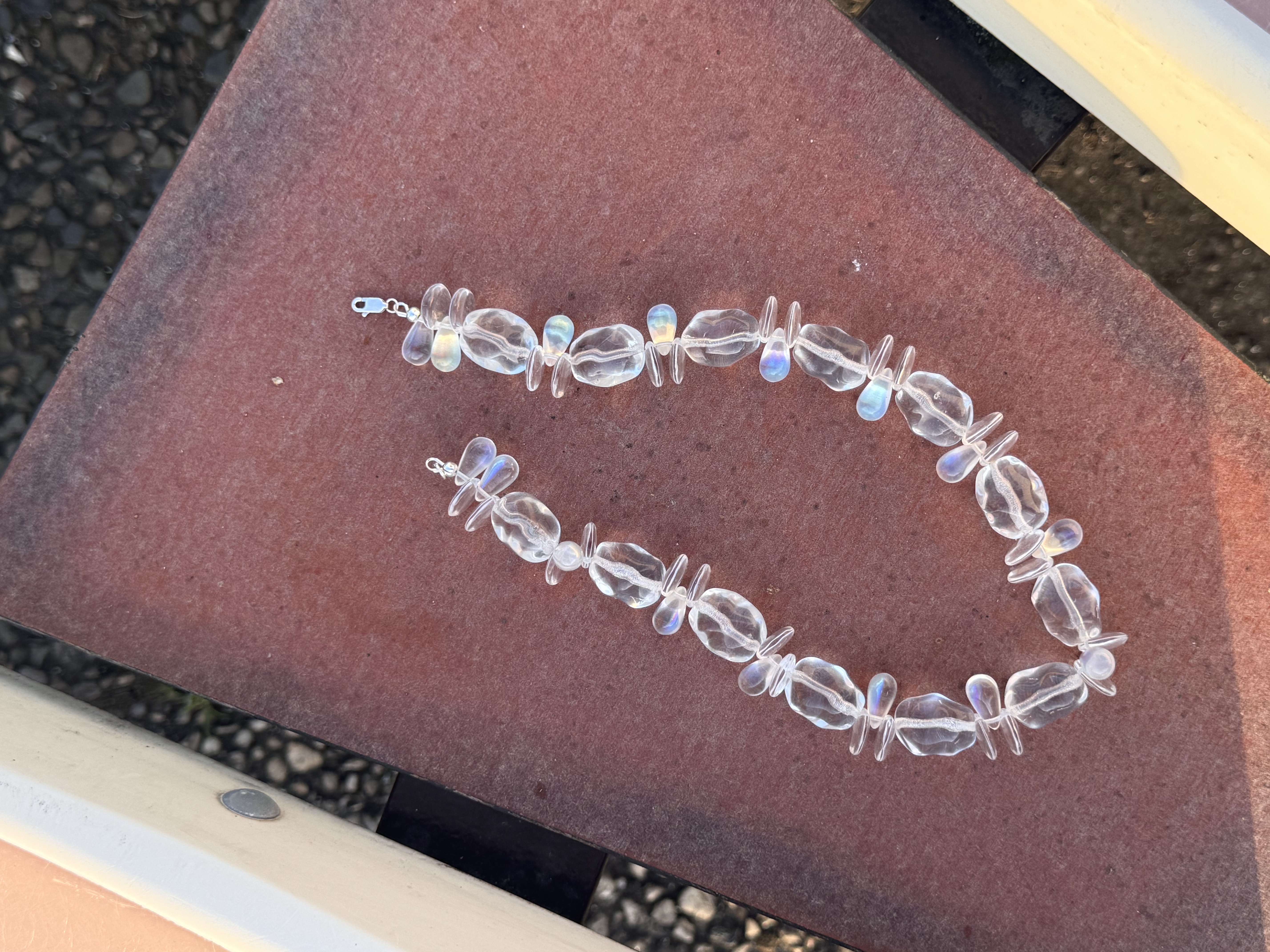A sculptural necklace of clear glass beads with iridescent drops. Light, fluid, and luminous — inspired by reflections of water and movement.

Glass beads 
Sterling silver hardware

42 cm length

Handcrafted in Berlin