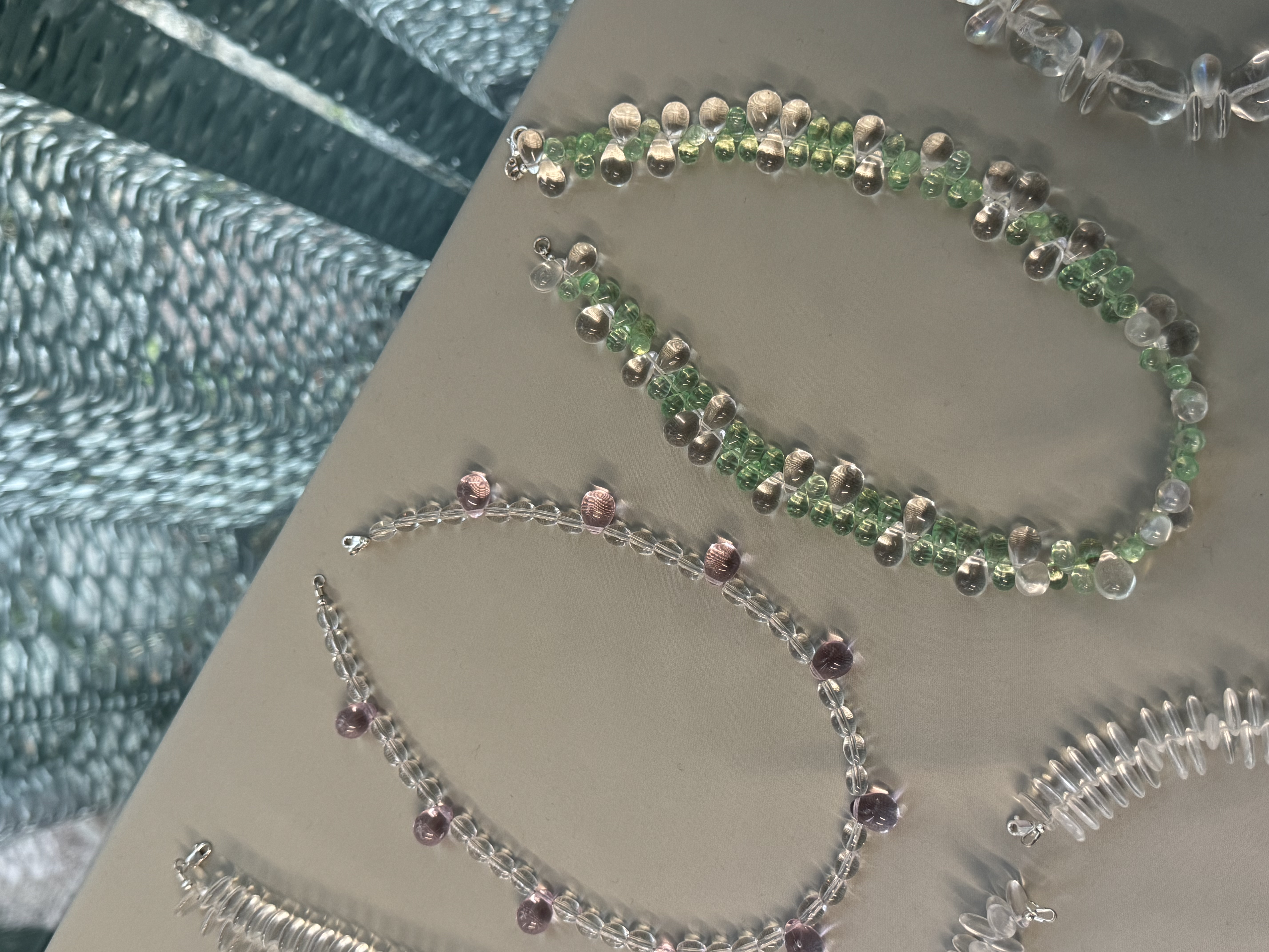A short necklace made of round, translucent beads in soft green and clear tones, arranged in a layered, sculptural pattern. Lightweight and comfortable, it sits neatly on the neckline and adds a subtle color accent to everyday looks.
Glass beads
Sterling silver hardware
47 cm length
Handcrafted in Berlin