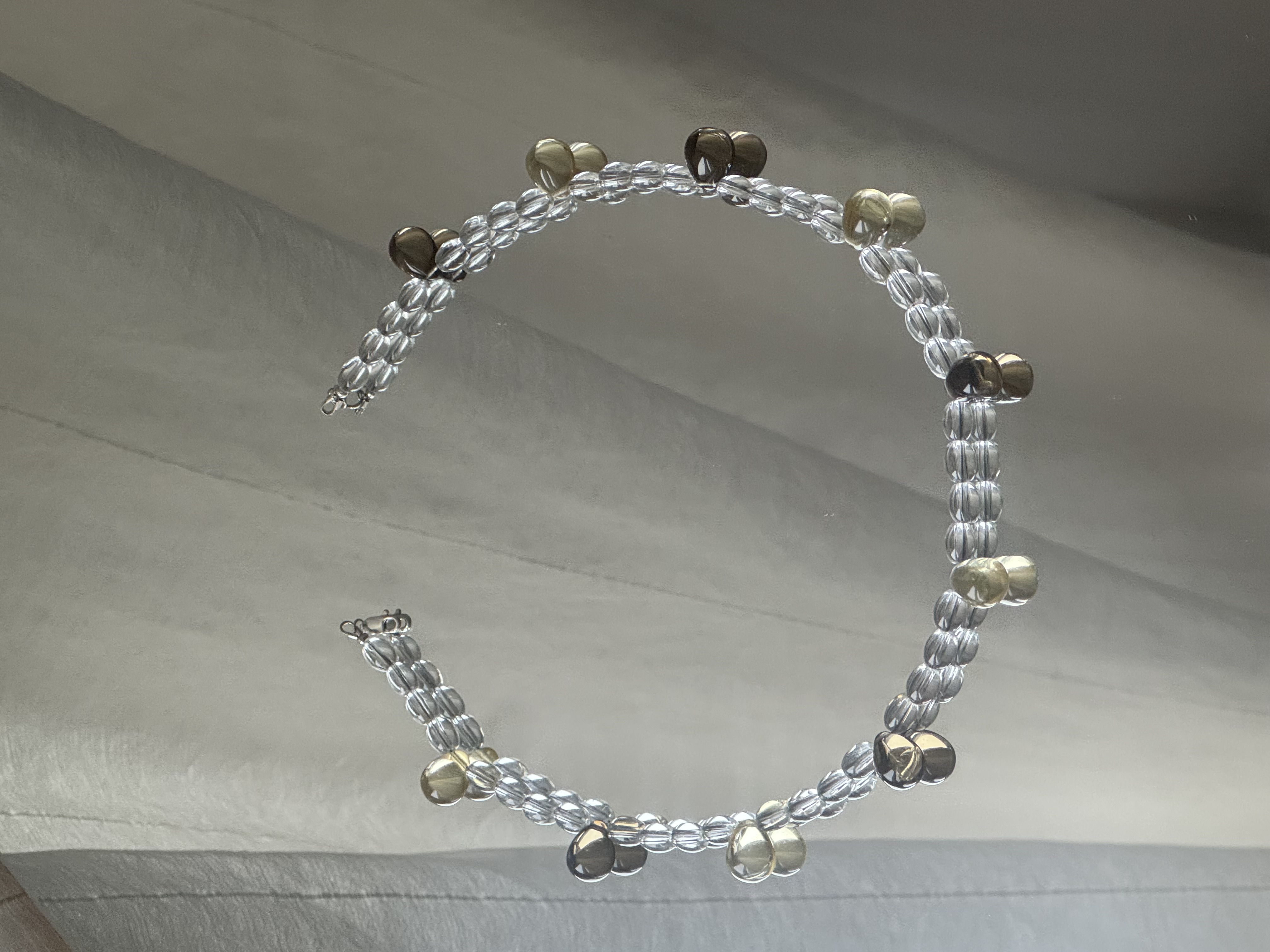 A short necklace made of clear, transparent beads accented with small colorful drops. The beads are arranged in a layered, sculptural pattern that catches the light with every movement. 

Glass beads 
Sterling silver hardware

47 cm length

Handcrafted in Berlin