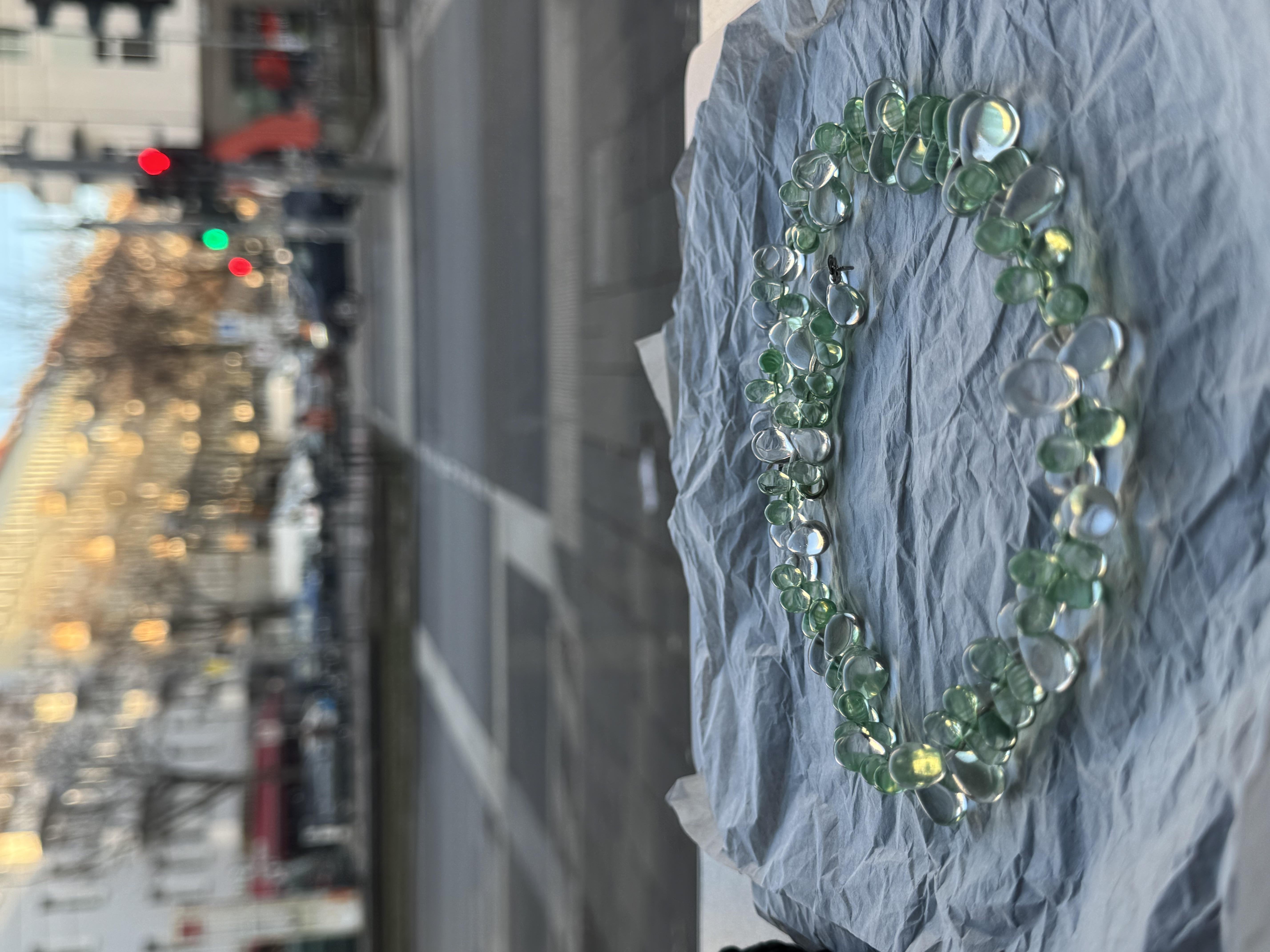 A short necklace made of round, translucent beads in soft green and clear tones, arranged in a layered, sculptural pattern. Lightweight and comfortable, it sits neatly on the neckline and adds a subtle color accent to everyday looks.
Glass beads
Sterling silver hardware
47 cm length
Handcrafted in Berlin