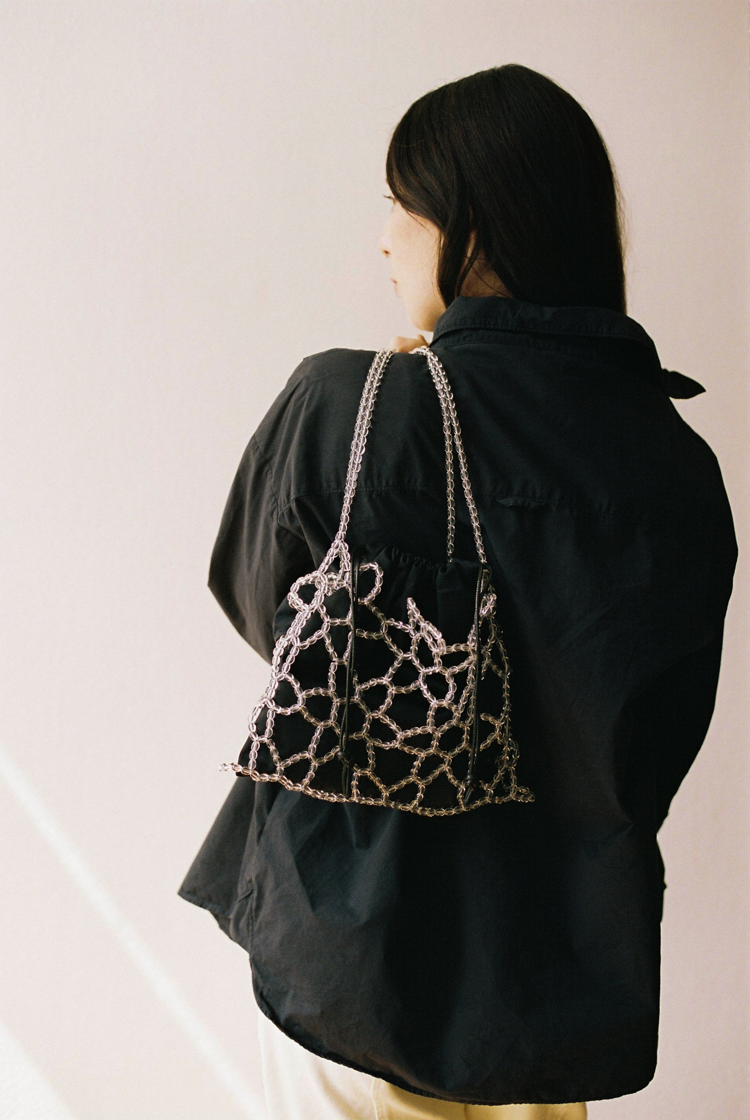 Transparent beaded bag with a structured net design and a long shoulder strap. Lightweight and see-through, suitable for carrying small essentials and styling over outfits.

Approx. 28 cm x 19 cm 
Strap length - 43 cm

Clear glass beads
Includes a removable black cotton pouch

We recommend carrying only essentials such as your phone, lipstick, wallet and sunglasses. Since we use metal thread for weaving, we advise avoiding direct contact with water.

Handmade in Kyiv